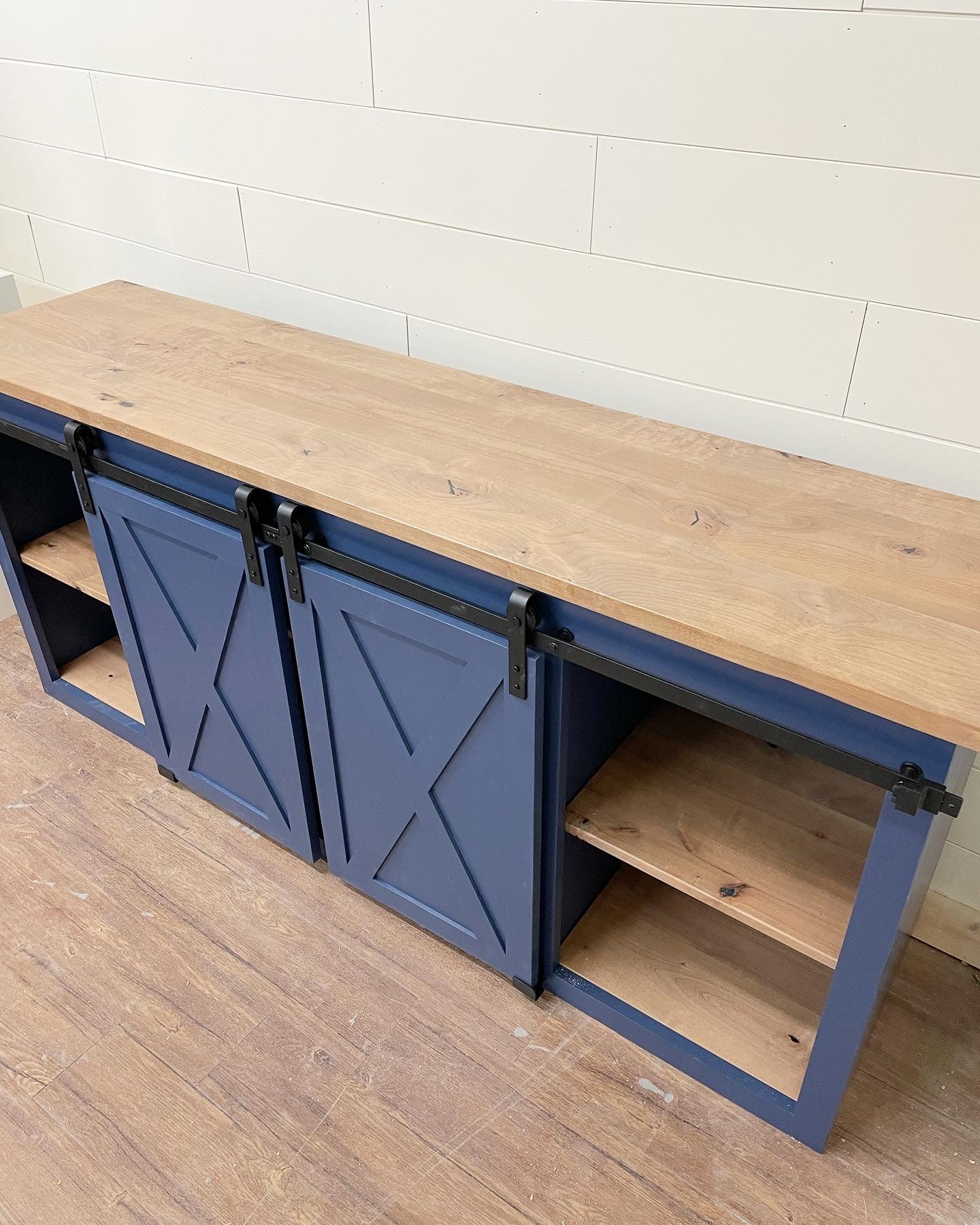 Pictured is a 72" L x 18" D x 36" T console with a Rustic Alder top and shelves with Weathered Oak Stain and Indigo Batik painted base.