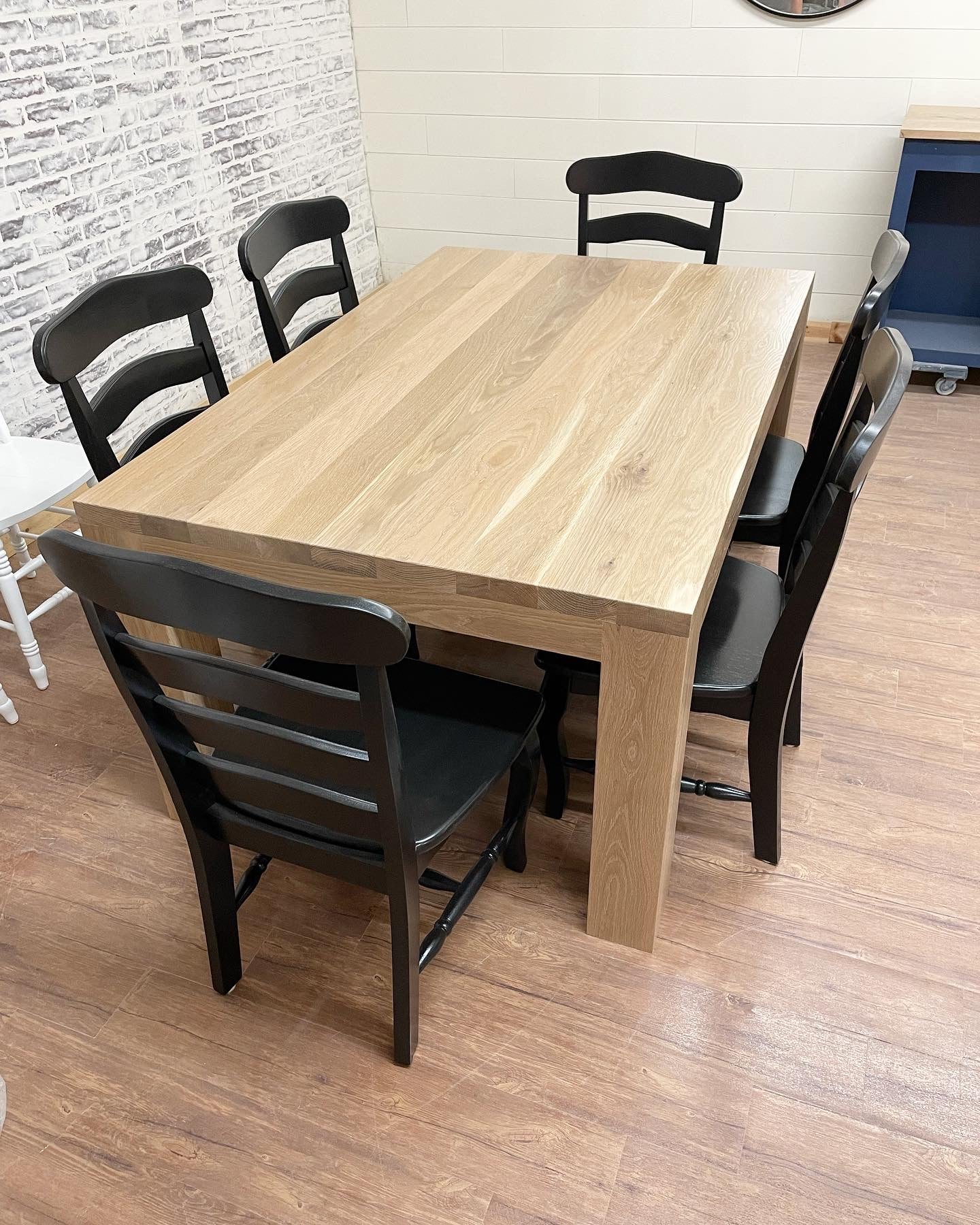 Pictured is a 5.5' L x 42" W White Oak table with Pickled Oak stain. Pictured are 6 French Country Chairs painted Black.